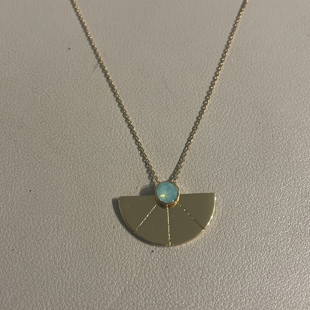 Trina Turk half circle pendent with light blue stone